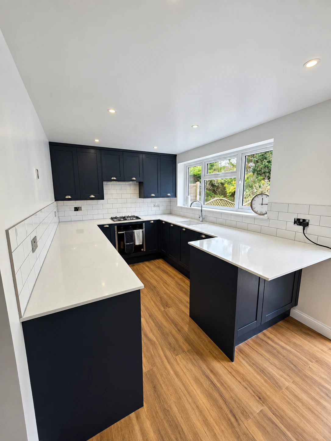 Refurbished kitchen with navy units and white worktops