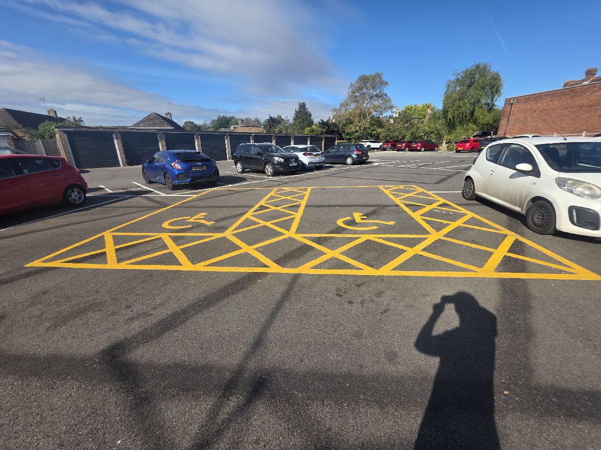 Accessible parking bay with new yellow hatched markings and wheelchair symbols